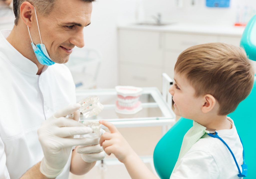 Un praticien explique le traitement à un enfant Dentéclair Pairs 14